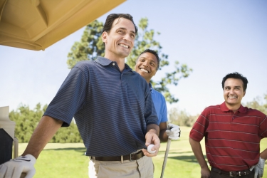 Group of smiling male golfers on course